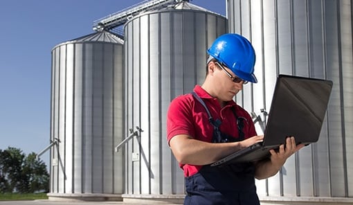 Man working on laptop at agricultural business
