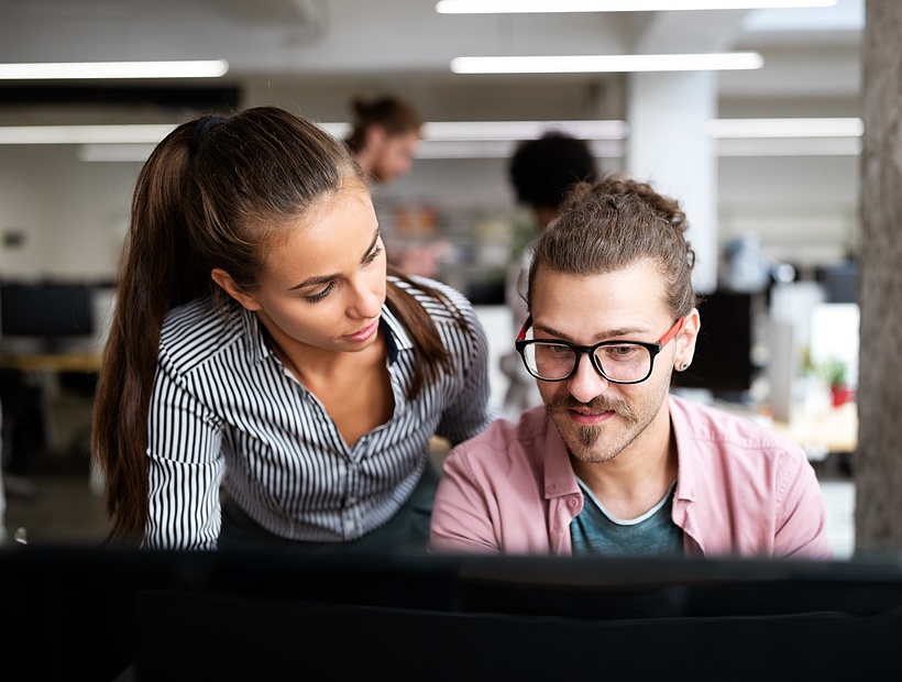 man and woman looking at a computer